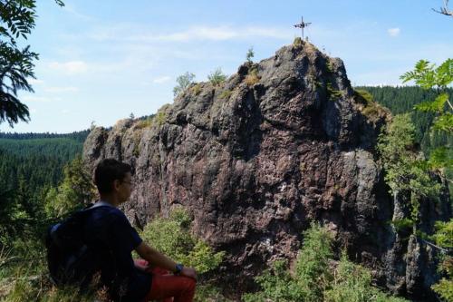 a person sitting on top of a rock with a cross on it at Thüringer Waldbaude in Tambach-Dietharz