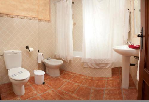 a bathroom with a toilet and a sink at Hotel Rural El Arriero in La Zarza