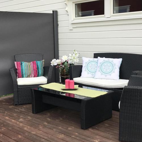 a patio with two chairs and a table with a coffee table at Marisletta farm - house by the sea in Tromsø