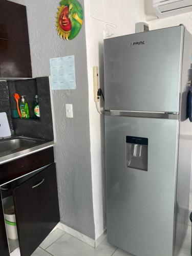 a stainless steel refrigerator in a kitchen with a sink at Cancun Oceanfront, Entire Apartment in Cancún