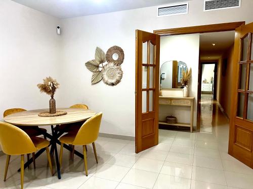 a dining room with a table and yellow chairs at Apartamento céntrico junto paseo, playas y zonas de interés!! in Águilas