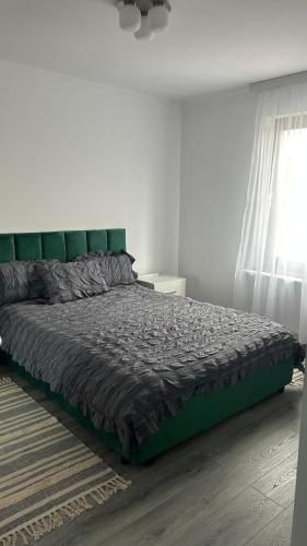 a bedroom with a large bed with a green headboard at Palko Residence 2 in Ocna-Mureşului