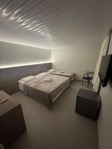 a room with two beds in a white room at Hotel Pousada Villa Marina in Fortaleza