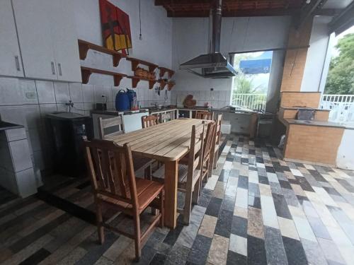 a large kitchen with a wooden table and chairs at Chácara Caçapava in Caçapava