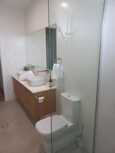 a bathroom with a toilet and a sink and a shower at Lillian Waters Retreat in Yamba