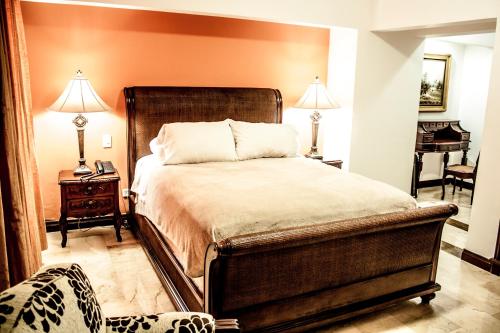 a bedroom with a bed and two lamps and a table at Hotel Boutique Villa Casuarinas in Cali