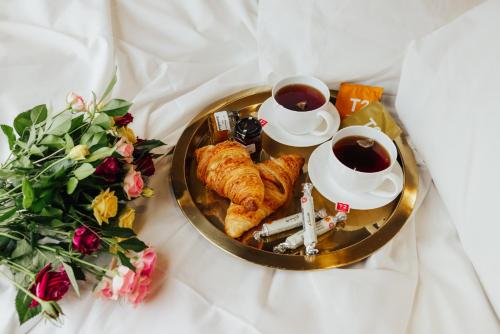 a tray with croissants and two cups of tea and flowers at Narrows Escape Rainforest Retreat in Montville