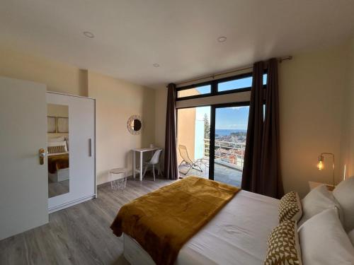 a bedroom with a large bed and a large window at Funchal Casa in Funchal