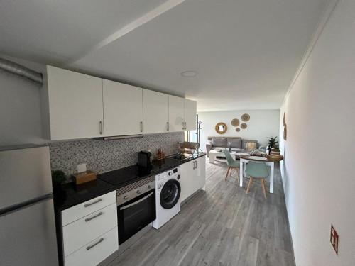 a kitchen with white cabinets and a table with chairs at Funchal Casa in Funchal