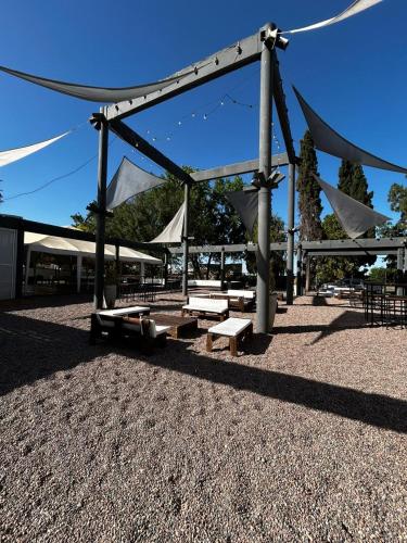 a pavilion with benches and tables in a park at Hostal de Los Andes in Rodeo de la Cruz