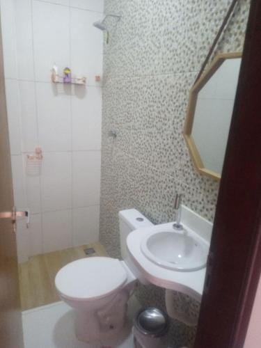 a bathroom with a toilet and a sink and a mirror at Apartamento próximo do aeroporto de João Pessoa e das principais praias in Bayeux