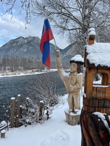 a statue holding a flag next to a bird house at Zaži Ubytovanie PIENINY by Zazi in Červený Kláštor