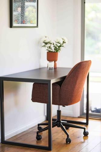 a black desk with a chair and a plant at Ziggys Erowal Bay in Erowal Bay