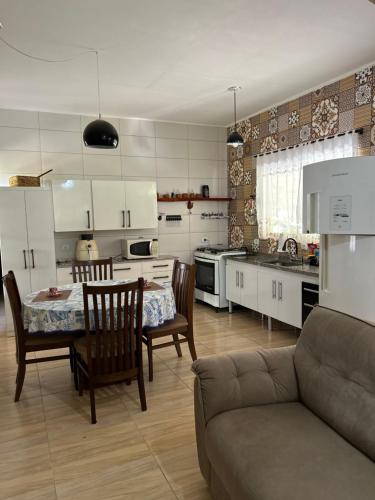 Una cocina y una sala de estar con mesa y sillas. en Casa com vista para as montanhas, en Sapucaí-Mirim