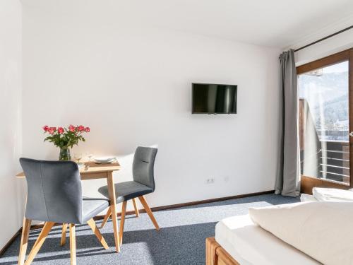 a room with a table and two chairs and a television at Brixen Alpin Living Top 1 und 2 und 3 in Brixen im Thale