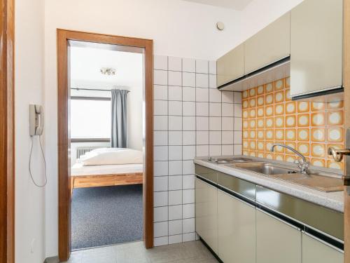 a kitchen with a sink and a room with a bed at Brixen Alpin Living Top 1 und 2 und 3 in Brixen im Thale