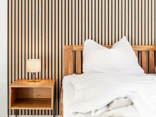 a bedroom with a bed and a wooden wall at Brixen Alpin Living Top 1 und 2 und 3 in Brixen im Thale