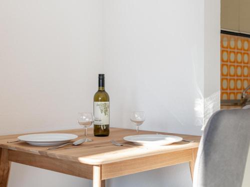 a table with a bottle of wine and two glasses at Brixen Alpin Living Top 1 und 2 und 3 in Brixen im Thale