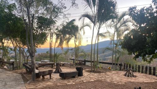 a park with benches and palm trees with a view at Hotel SPA Campestre Los Adobes in Taxco de Alarcón