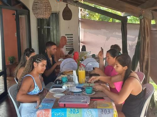 a group of people sitting at a table at Destino Hospeda in Pipa