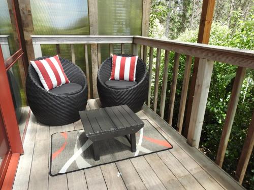 two wicker chairs and a table on a deck at The Lookout- Clevedon in Clevedon