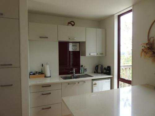 a kitchen with white cabinets and a sink at The Lookout- Clevedon in Clevedon