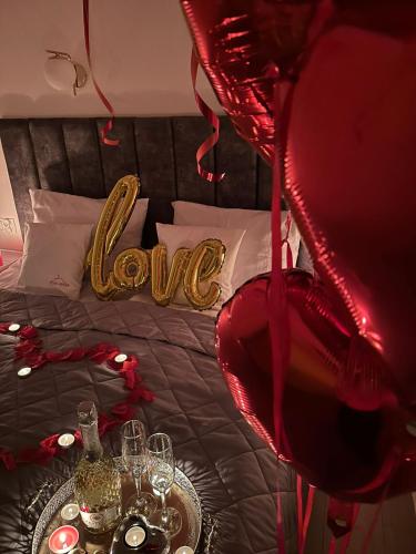 a bedroom with a bed with a love sign on it at Etna Apart in Łeba