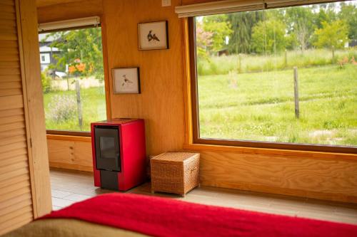 a small red refrigerator in a room with a window at Casa Rayen in Puerto Varas