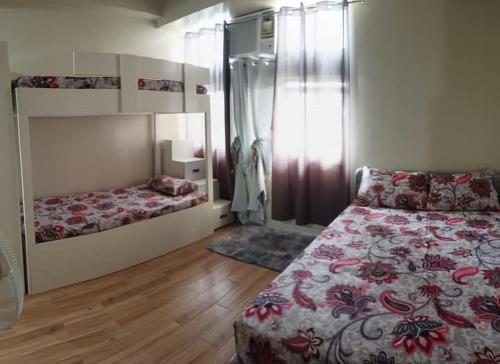 a bedroom with two beds and a large window at Holland Park Condominium Accommodation Southwoods Biñan Laguna- Max 4 Persons including kids & toddlers in Biñan