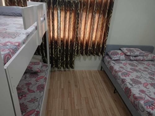 a room with two beds and a window with curtains at Holland Park Condominium Accommodation Southwoods Biñan Laguna- Max 4 Persons including kids & toddlers in Biñan