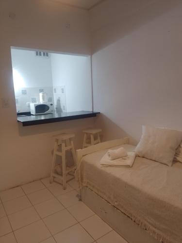 a bedroom with a bed and a counter with a kitchen at Levain Apart in Trenque Lauquen