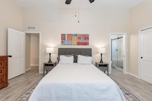 a white bedroom with a large bed with two lamps at 4-bedroom house in Gilbert - Remodeled Retreat in Gilbert
