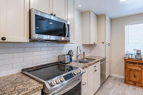 a kitchen with a sink and a microwave at 4-bedroom house in Gilbert - Remodeled Retreat in Gilbert