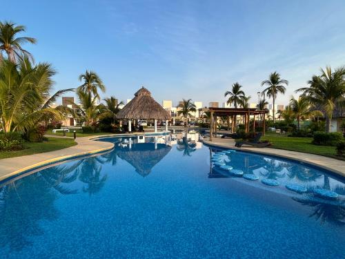 a large blue swimming pool with a gazebo and palm trees at New Modern Acapulco Diamante House Getaway with Pool View and Beach Club in Acapulco