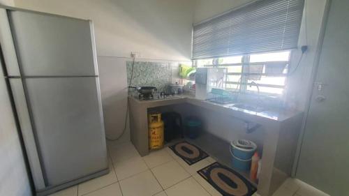 a small kitchen with a sink and a refrigerator at MZ Zora Homestay in TanjongMalim