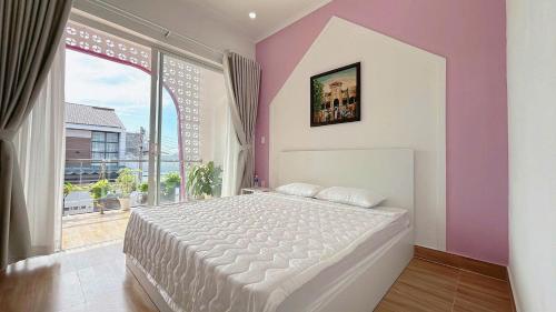a bedroom with a large bed and a large window at Homestay NAD nguyên căn tại Phan Thiết in Ấp Sung Xuân