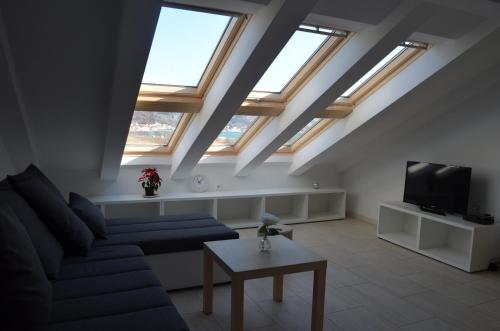 un salon avec des puits de lumière, un canapé et une télévision dans l'établissement Apartments Mare, à Baška