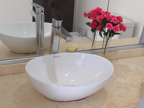 baño con lavabo y jarrón de flores en Movistar Arena, en Buenos Aires