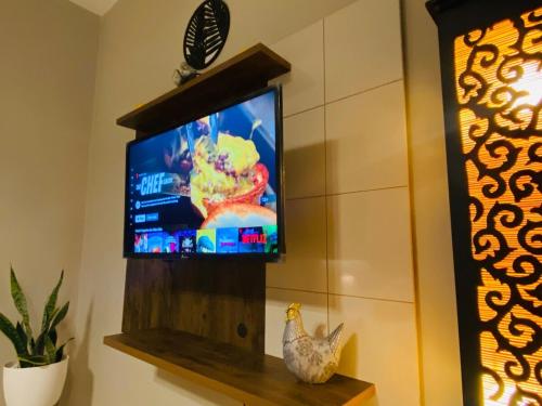 a television in a room with a chicken sitting on a shelf at Sambo Suite Wifi Parking Samborondon in SamborondÃ³n