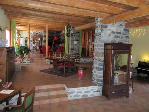 - un salon avec un mur en pierre et une table dans l'établissement Bastides Du Mezenc, à Saint-Front