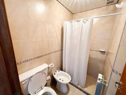 a small bathroom with a toilet and a shower at Apart San Jose in Villa Carlos Paz