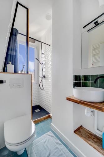 une salle de bain avec des toilettes blanches et un lavabo dans l'établissement Appartement neuf à 20 des Champs Élysées, à Saint-Ouen