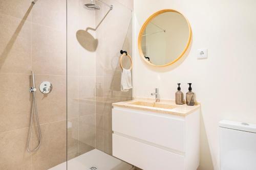 a bathroom with a shower and a sink and a mirror at Big apt 4beds with terrace, 15 mins to Lisbon in Almada