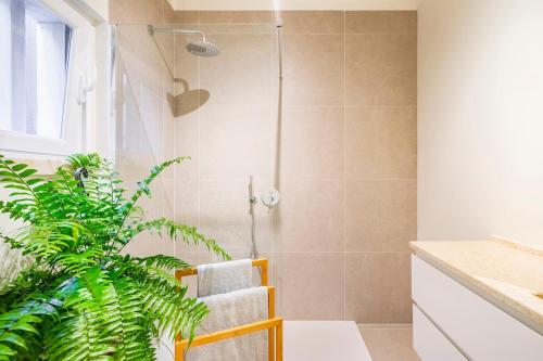 a bathroom with a shower and a plant at Big apt 4beds with terrace, 15 mins to Lisbon in Almada