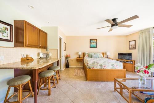 a bedroom with a bed and a kitchen with a table at Amazing condo peaks of ocean view On Ali'i Dr by surf spots in Kailua-Kona