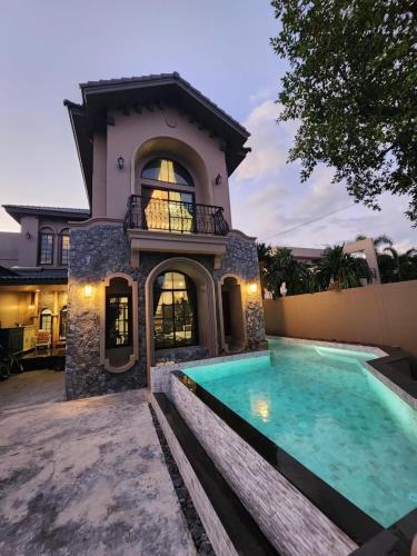 a house with a swimming pool in front of it at T1-Tuscany Private Pool Villa-บางแสน in Ban Hua Khao Sammuk