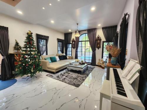 a living room with a christmas tree and a piano at T1-Tuscany Private Pool Villa-บางแสน in Ban Hua Khao Sammuk