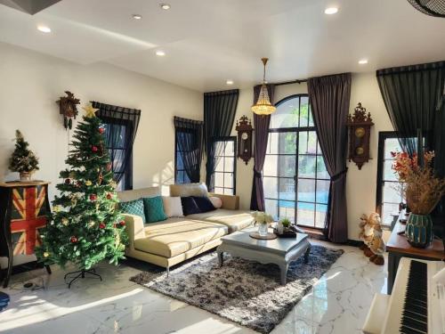 a living room with a christmas tree and a couch at T1-Tuscany Private Pool Villa-บางแสน in Ban Hua Khao Sammuk