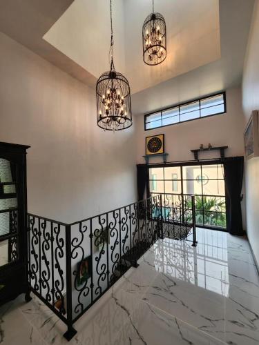 a staircase in a house with two chandeliers at T1-Tuscany Private Pool Villa-บางแสน in Ban Hua Khao Sammuk