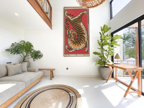 een woonkamer met een bank en een tapijt bij CARI Surf Camp & Studio's in Uluwatu